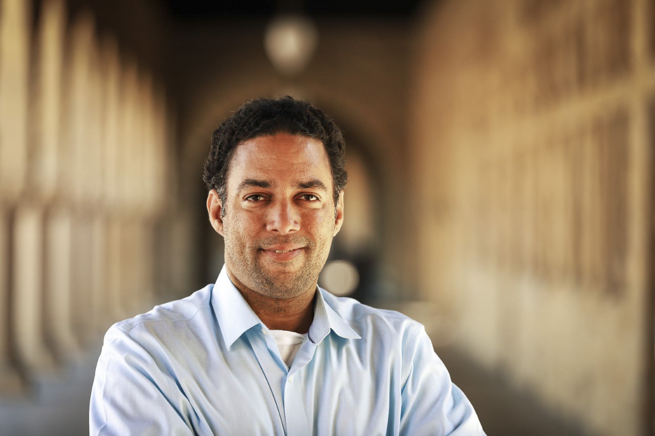 Professor Adam Banks Smiling in front of the Stanford Arches